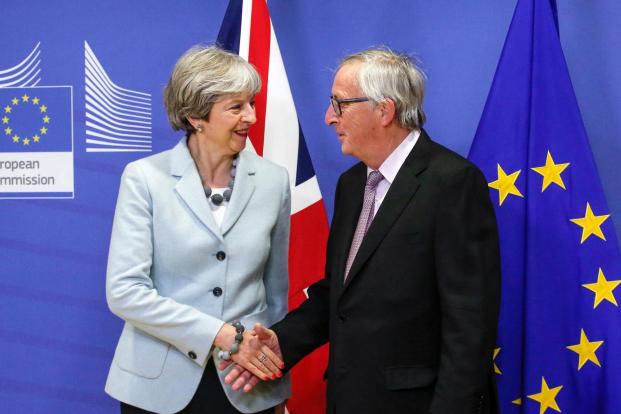 Theresa May shakes hands with European Commission President Jean-Claude Juncker after securing the first stage of the Brexit deal: Bloomberg via Getty Images