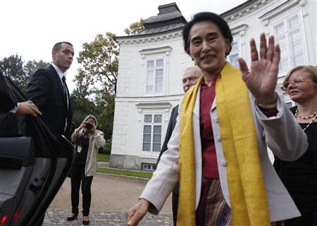 Myanmar's opposition leader Aung San Suu Kyi waves after her meeting with former Polish president Lech Walesa (3rd R) in Myslewicki Palace in Warsaw September 12, 2013. REUTERS/Kacper Pempel