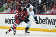 New Jersey Devils' Nico Hischier (13) drives past Seattle Kraken's Alex Wennberg (21) during the first period of an NHL hockey game Tuesday, Oct. 19, 2021, in Newark, N.J. (AP Photo/Frank Franklin II)