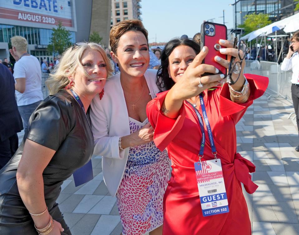 Former Arizona Republican gubernatorial candidate Kari Lake takes photos with supporters at Fiserv Forum before the Republican presidential debate in Milwaukee on Wednesday.