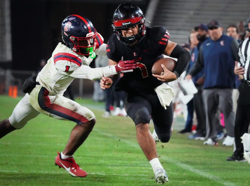 Liberty quarterback Navi Bruzon (7) runs past Centennial defender Kenneth Worthy (1) during the Open Division State Championship at Mountain America Stadium in Tempe on Dec. 2, 2023.
