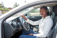 Rwandan Joseline Iradukunda sits inside her "Move" app-driven ride-hailing service Volkswagen Polo in Kigali