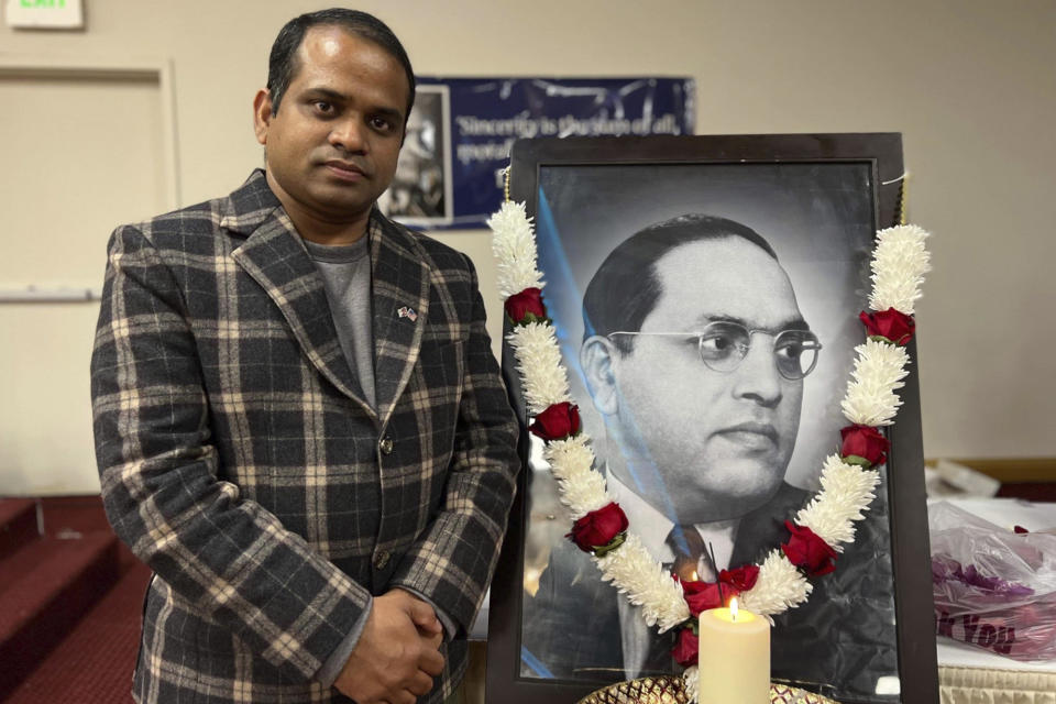 In this photo provided by Prem Pariyar, a Dalit Hindu from Nepal, he stands in front of a photo of Bhimrao Ramji Ambedkar, during at a Dalit History Month event in Newark, Calif., in April 2022. Ambedkar, an untouchable, or dalit, and a prominent Indian freedom fighter, was the chief architect of the Indian Constitution, which outlawed discrimination based on caste. (Courtesy of Prem Pariyar)