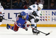 New York Rangers' Mike Zibanejad (93) and San Jose Sharks' Mario Ferraro (38) battle for the puck during the first period of an NHL hockey game Friday, Dec. 3, 2021, in New York. (AP Photo/John Munson)