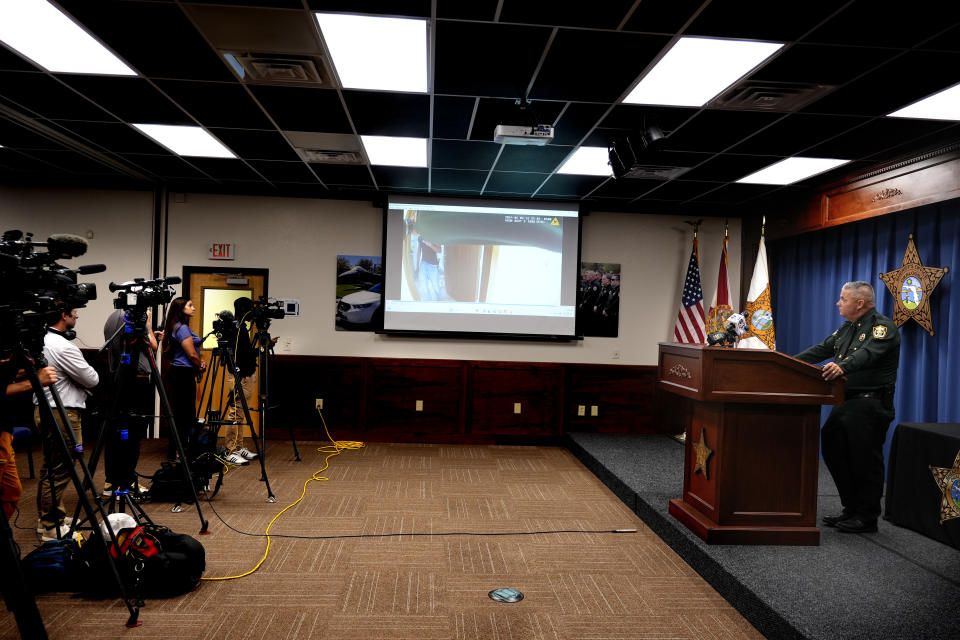 CORRECTS SERVICE BRANCH TO U.S. AIR FORCE INSTEAD OF U.S. NAVY - Okaloosa County Sheriff Eric Aden holds a news conference where he shared deputy body cam footage, displayed on screen at center, of the May 3, 2024 shooting of Roger Fortson, a U.S. Air Force senior airman, Thursday, May 9, 2024, in Fort Walton Beach, Fla. Fortson was shot in his apartment after a response to a complaint. (AP Photo/Gerald Herbert)