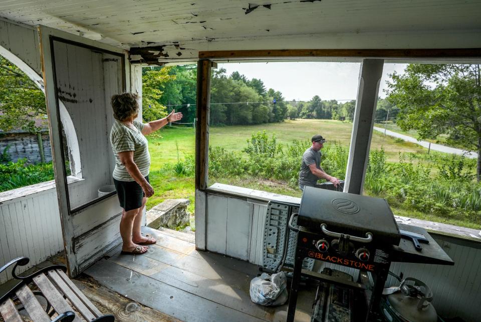 Jo-Ann Lemaire, with son Frank in the background, looks out on what was once a cow pasture on her family's land.