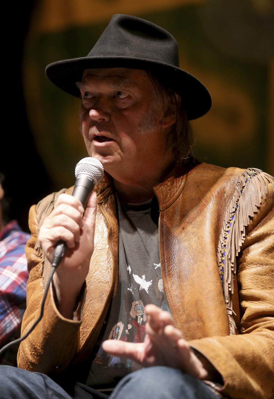 Musician Neil Young addresses the media before the "Honor The Treaties" concert series at the Centennial Concert Hall in Winnipeg, Manitoba, January 16, 2014. Young is touring to raise money for the Athabasca Chipewyan First Nation aboriginal group, which is trying to prevent the expansion of tar sands development. REUTERS/Trevor Hagan (CANADA - Tags: POLITICS ENTERTAINMENT ENVIRONMENT ENERGY SOCIETY)