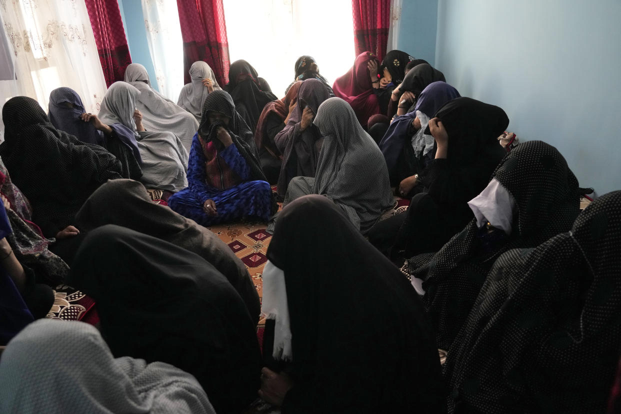 The family of a 19-years old girl who was victim of a suicide bomber mourns, in Kabul, Afghanistan, Friday, Sept. 30, 2022. A Taliban spokesman says a suicide bomber has killed several people and wounded others at an education center in a Shiite area of the Afghan capital. The bomber hit while hundreds of teenage students inside were taking practice entrance exams for university, a witness says. (AP Photo/Ebrahim Noroozi)