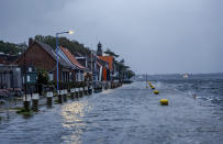 A street in front of the cafes and stores at Tiessenkai in the Kiel district of Holtenau is completely flooded by the Baltic Sea Friday, Oct. 20, 2023. (Axel Heimken/dpa via AP)