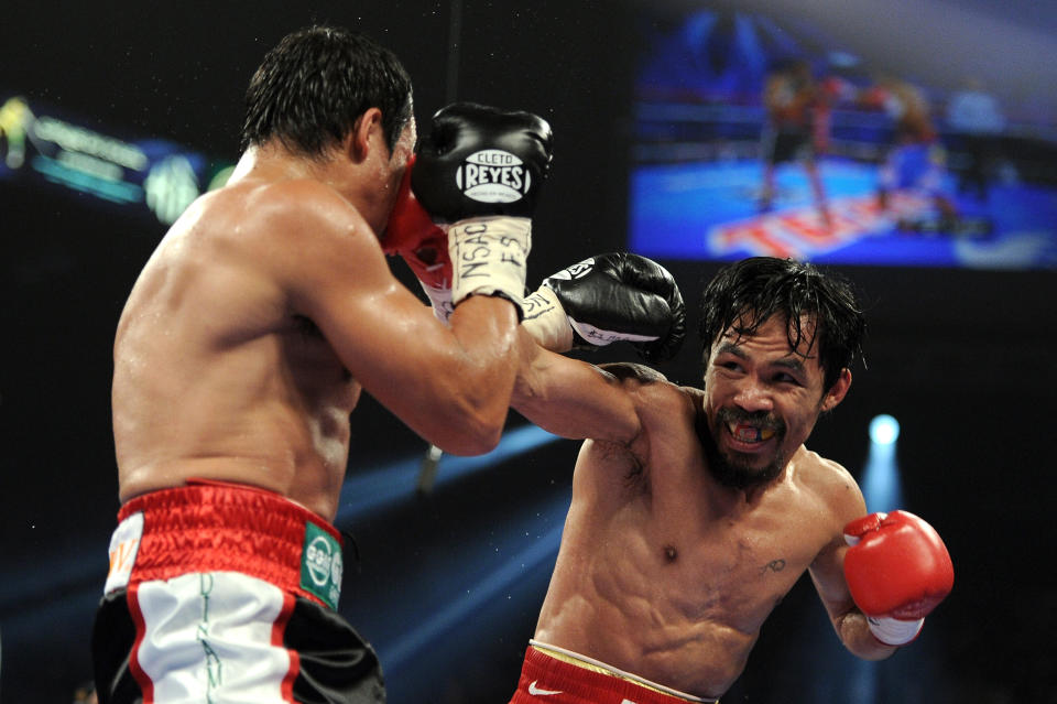 LAS VEGAS, NV - NOVEMBER 12: (R-L) Manny Pacquiao throws a right to the head of Juan Manuel Marquez during the WBO world welterweight title fight at the MGM Grand Garden Arena on November 12, 2011 in Las Vegas, Nevada. (Photo by Harry How/Getty Images)