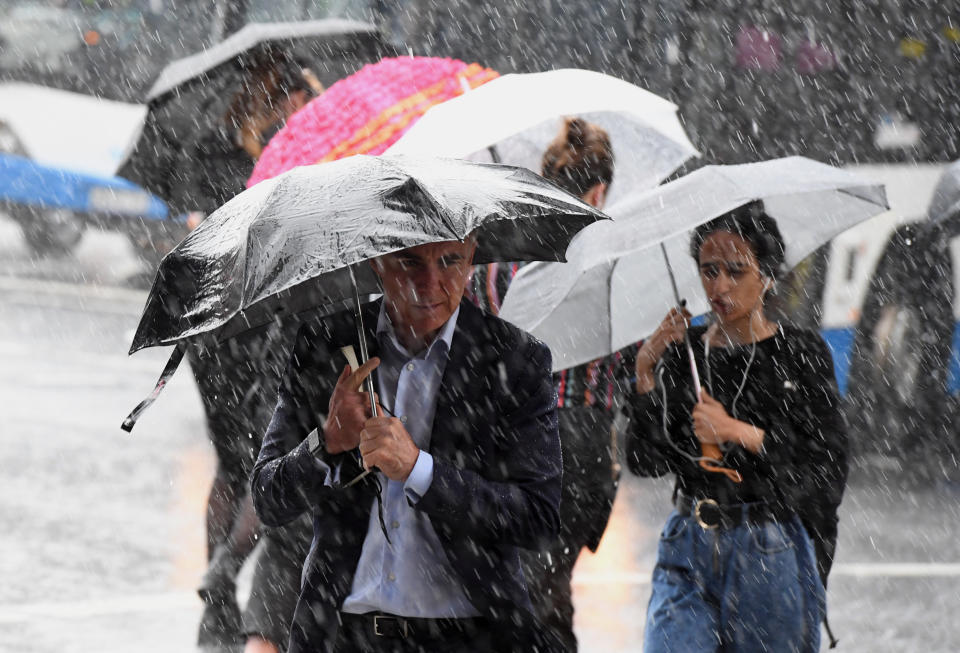 Pedestrians hold umbrellas during wet weather in Sydney.