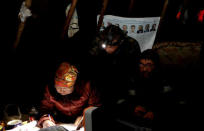 Herders of the agricultural cooperative organisation "Erv" wait as a local electoral commission member fills documents during the early voting in remote areas ahead of the presidential election, at a reindeer camping ground, about 250 km north of Naryan-Mar, in Nenets Autonomous District, Russia, March 8, 2018. REUTERS/Sergei Karpukhin