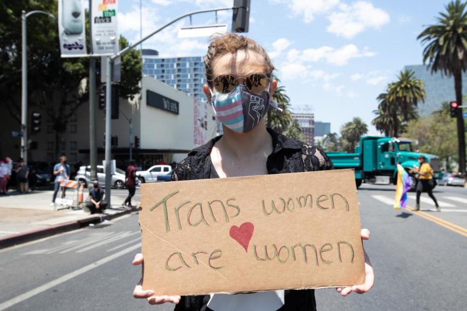 A counter protester at Wi Spa on 3 July holds a sign that says “Trans women are women.”