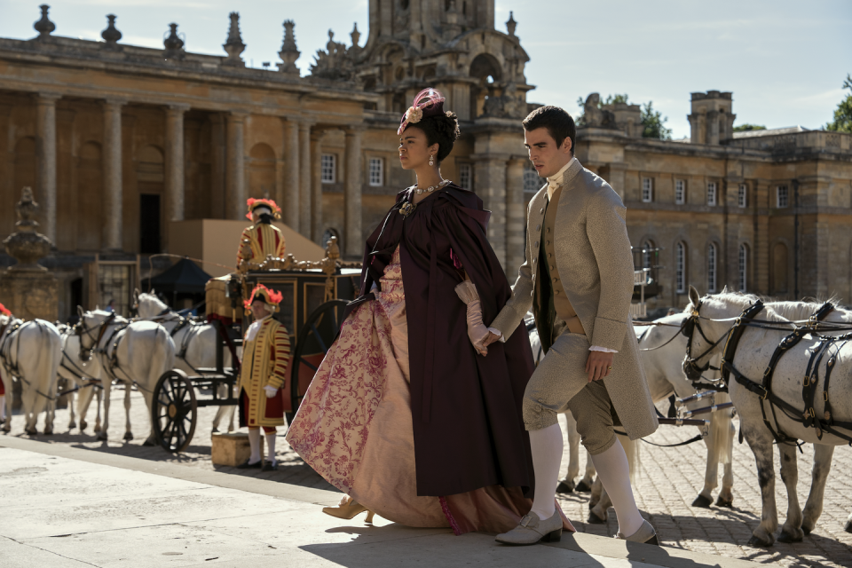 india amarteifio as young queen charlotte and corey mylchreest as young king george walking up stairs in episode 106 of queen charlotte