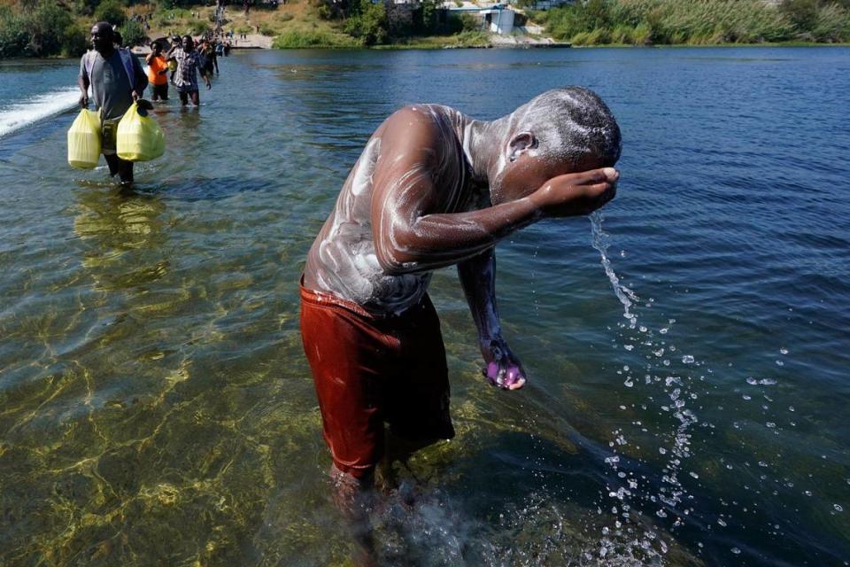 A Haitian migrant uses the Rio Grande to take a bath after crossing a dam from Mexico to the United States, Friday, Sept. 17, 2021, in Del Rio, Texas.