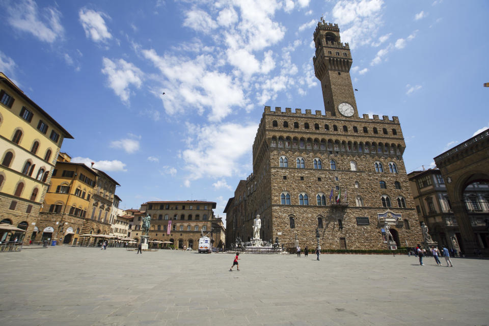 People walk in an unusually uncrowded historical Piazza della Signoria square, in Florence, Italy, Wednesday, June 3, 2020. The Uffizi museum reopened to the public after over two months of closure due to coronavirus restrictions. (AP Photo/Andrew Medichini)