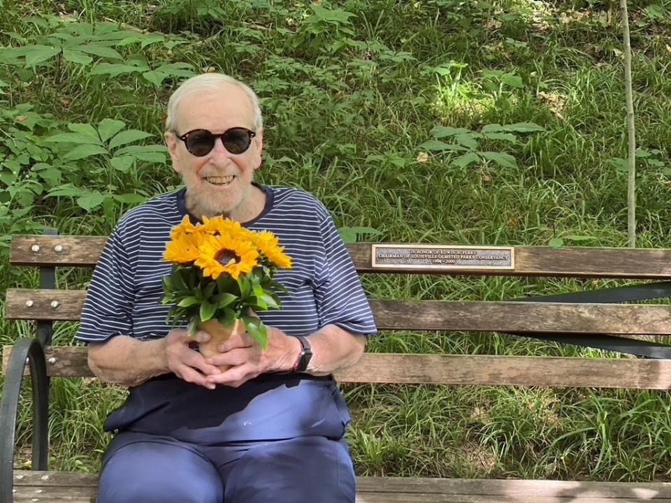 Edwin Perry at his bench in Cherokee Park, July 2022. The bench is dedicated to him for his work at the Olmsted Parks Conservancy.