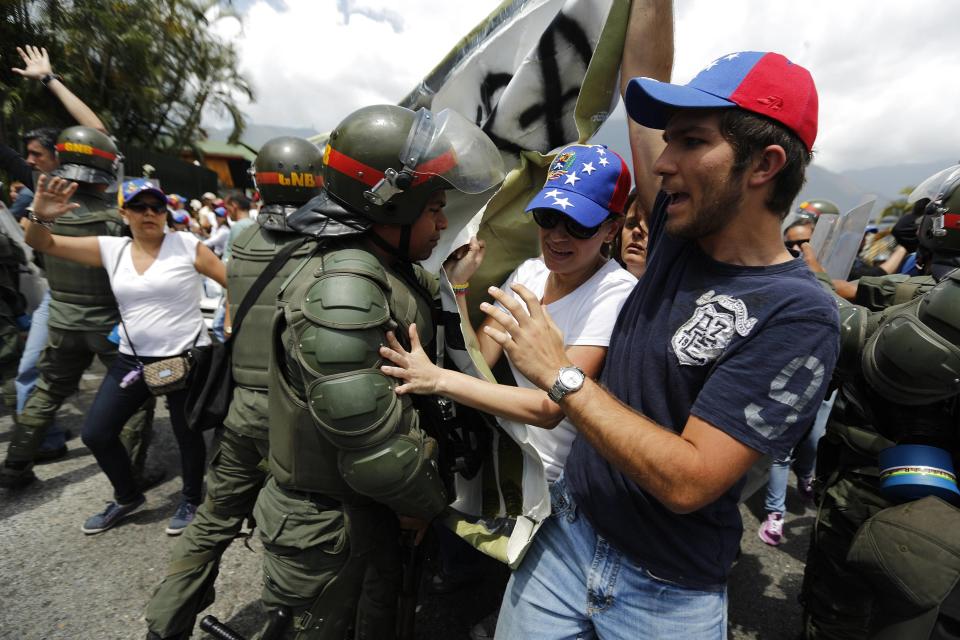 Anti-government protesters scuffle with national guards as they march by Generalisimo Francisco de Miranda Airbase in Caracas