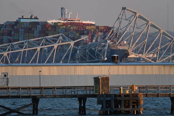 The steel frame of the Francis Scott Key Bridge sits on top of a container ship after it struck the bridge in Baltimore, Maryland, on March 26, 2024. The collapsed sent multiple vehicles and up to 20 people plunging into the harbor below. 