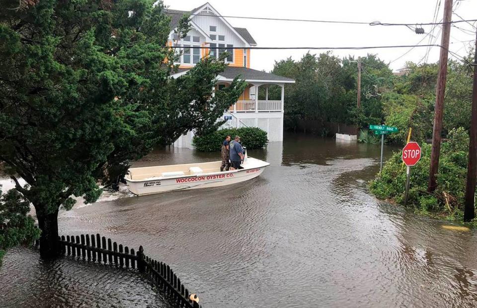 Ocracoke Volunteer Fire Department chief Albert O’Neal, in blue shirt, boats down Sunset Drive on his way to seek out islanders stranded in their flooded homes in the aftermath of Hurricane. Dorian Friday, Sept. 6, 2019 on Ocracoke Island, N.C.