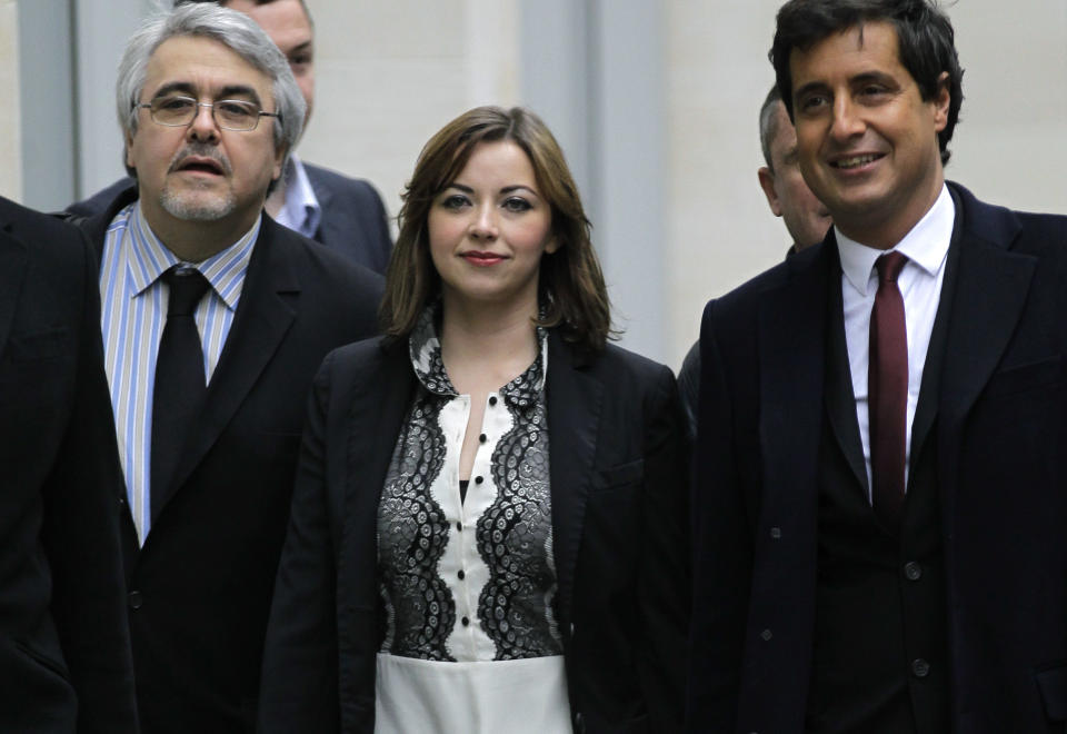 Singer Charlotte Church, center, arrives with her legal team at the High Court in London to hear the reading of a statement setting out the terms of the settlement for phone hacking damages claim against News International, Monday, Feb. 27, 2012. Charlotte Church, who testified before a media inquiry of being hounded by Rupert Murdoch's journalists when she was a teen singing sensation, received 600,000 pounds ($951,000) on Monday in a phone hacking settlement from News International and said she had been sickened by what she had learnt about intrusion into her private life. (AP Photo/Sang Tan)