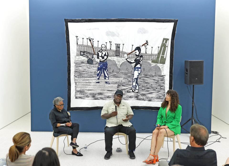 Gary Tyler speaks during an exhibit showcasing his work at Library Street Collective. Artist Carole Harris, left, and curator Allison Glenn, right, were also part of Saturday's show opening.