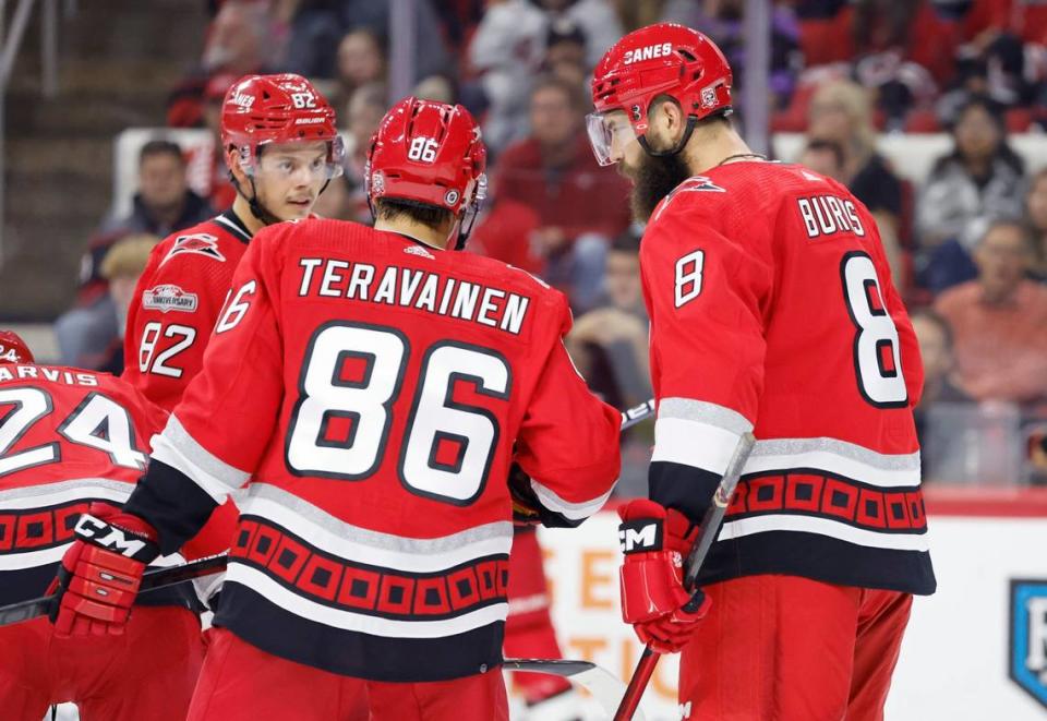 Carolina defenseman Brent Burns (8) talks with Teuvo Teravainen (86) and Jesperi Kotkaniemi (82) during the first period of the Carolina Hurricanes game against the Columbus Blue Jackets at PNC Arena in Raleigh, N.C., Wednesday, Oct. 12, 2022.