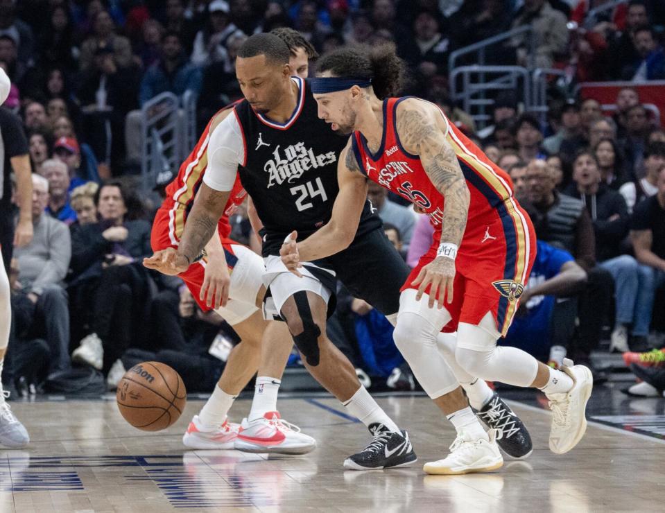 Clippers guard Norman Powell, left, steals the ball from Pelicans guard Jose Alvarado during a game Feb. 7.