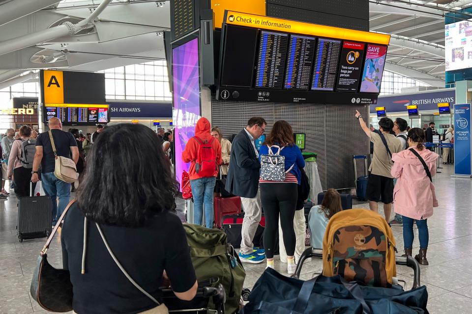 Passengers look at the departures board at Heathrow Airport (AP)