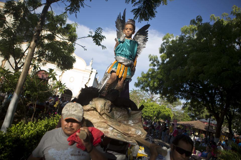 A boy dressed as Archangel Gabriel stands on a platform as he is carried in a Holy Week procession on Good Friday in Masaya, Nicaragua, Friday, April 18, 2014. Holy Week commemorates the last week of the earthly life of Jesus Christ culminating in his crucifixion on Good Friday and his resurrection on Easter Sunday. (AP Photo/Esteban Felix)