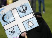 A woman holds a sign during a protest against the Quebec Charter of Values in Montreal, September 14, 2013. Thousands took to the streets to denounce the province's proposed bill to ban the wearing of any overt religious garb by government paid employees. REUTERS/ Christinne Muschi (CANADA - Tags: POLITICS CIVIL UNREST)