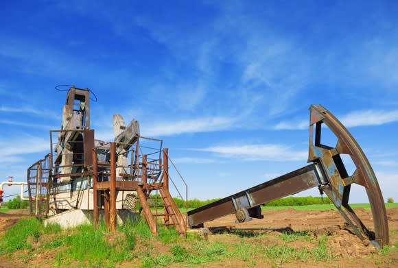 An abandoned oil pump jack in a field.