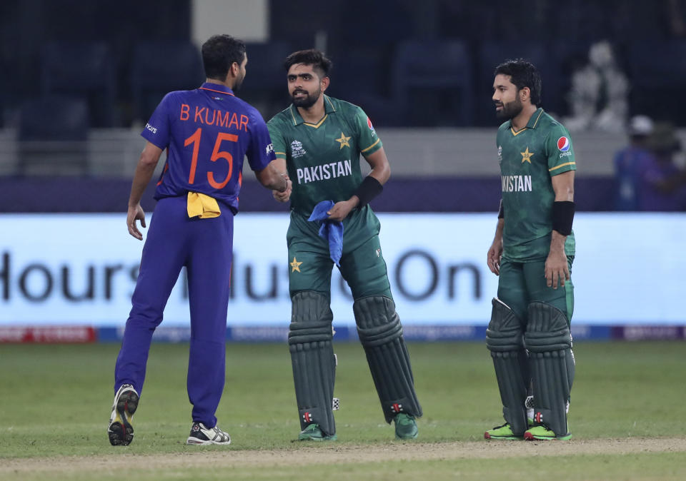 India's Bhuvneshwar Kumar congratulates Pakistan's cricket captain Babar Azam, centre and Mohammad Rizwan after Pakistan won the Cricket Twenty20 World Cup match between India and Pakistan in Dubai, UAE, Sunday, Oct. 24, 2021. (AP Photo/Aijaz Rahi)