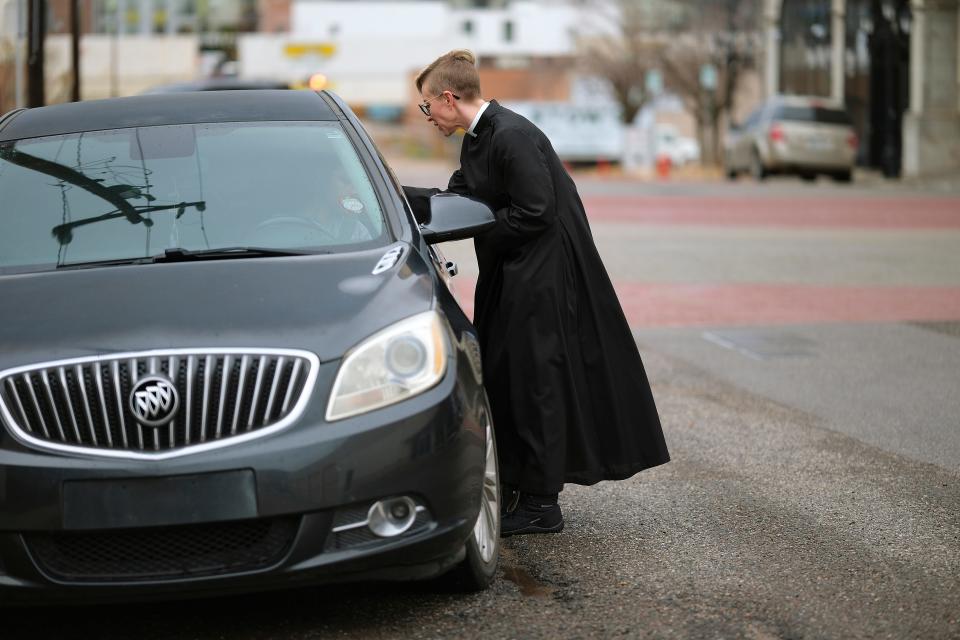 The Most Rev. Katie Churchwell, dean of St. Paul's Episcopal Cathedral, administers the imposition of ashes to a person in a car Wednesday.
