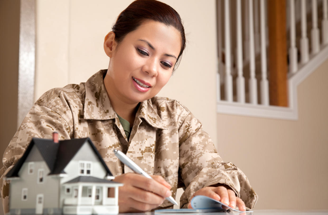 US Marine Female Soldier at Home with Real Estate Paperwork.