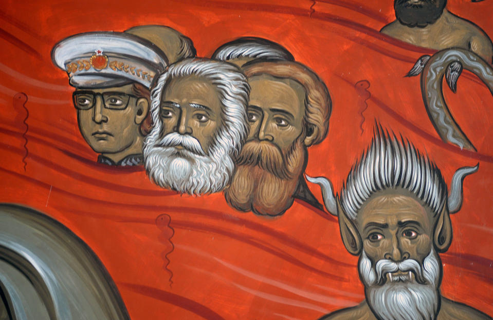 This photo taken Tuesday, Feb. 4, 2014 shows the brightly-colored newly painted fresco in the Serbian Orthodox Church of Christ's Resurrection in Montenegro's capital Podgorica. The fresco allegedly shows late Yugoslav autocratic leader Josip Broz Tito drowning in red fiery waves of hell with Karl Marx and Friedrich Engels, authors of the 1848 Communist Manifesto. They are in the company of Adam and Eve, together with some of Montenegro's current politicians and people wearing Muslim turbans. What appear to be rival church priests are being swallowed through a huge jaw of an angry gray beast with pointed devil ears. The fresco has triggered much attention and public controversy in this tiny former communist country. (AP Photo/Risto Bozovic)