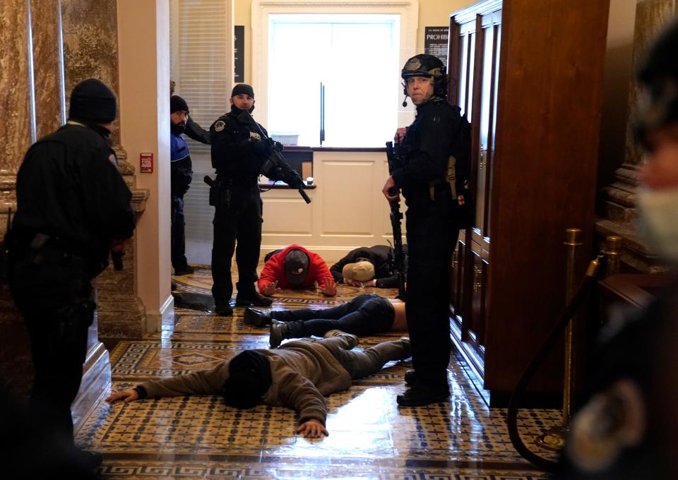 U.S. Capitol Police detain protesters at gunpoint outside of the House chamber, where a joint session of Congress had been meeting Jan. 6 to confirm the votes of the Electoral College.
