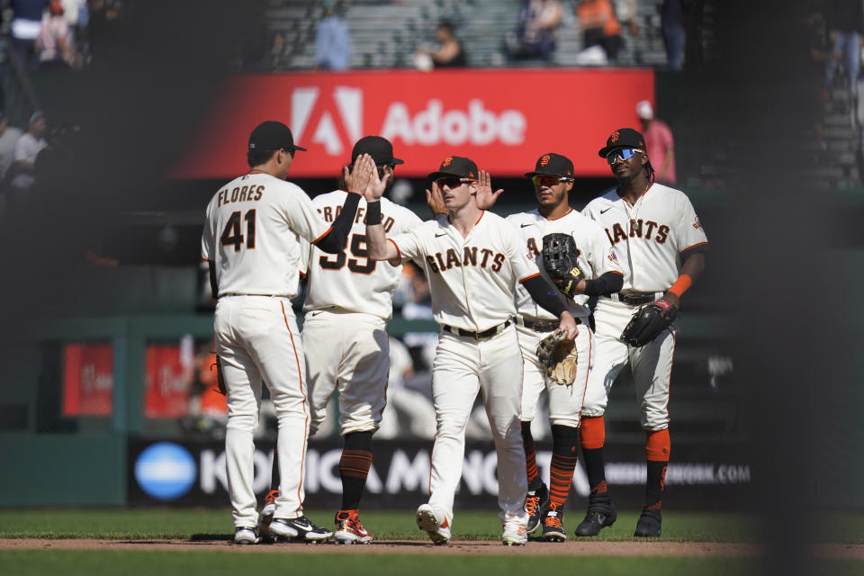 San Francisco Giants' Wilmer Flores, Brandon Crawford, Mike Yastrzemski, Thairo Estrada and Lewis Brinson, from left, celebrate the team's 4-1 victory against the Atlanta Braves in a baseball game in San Francisco, Wednesday, Sept. 14, 2022. (AP Photo/Godofredo A. Vásquez)
