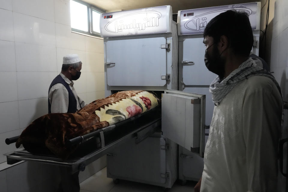 Afghan people move the body of a girl victim of a suicide bomber to a mosque, in Kabul, Afghanistan, Friday, Sept. 30, 2022. A Taliban spokesman says a suicide bomber has killed several people and wounded others at an education center in a Shiite area of the Afghan capital. The bomber hit while hundreds of teenage students inside were taking practice entrance exams for university, a witness says. (AP Photo/Ebrahim Noroozi)