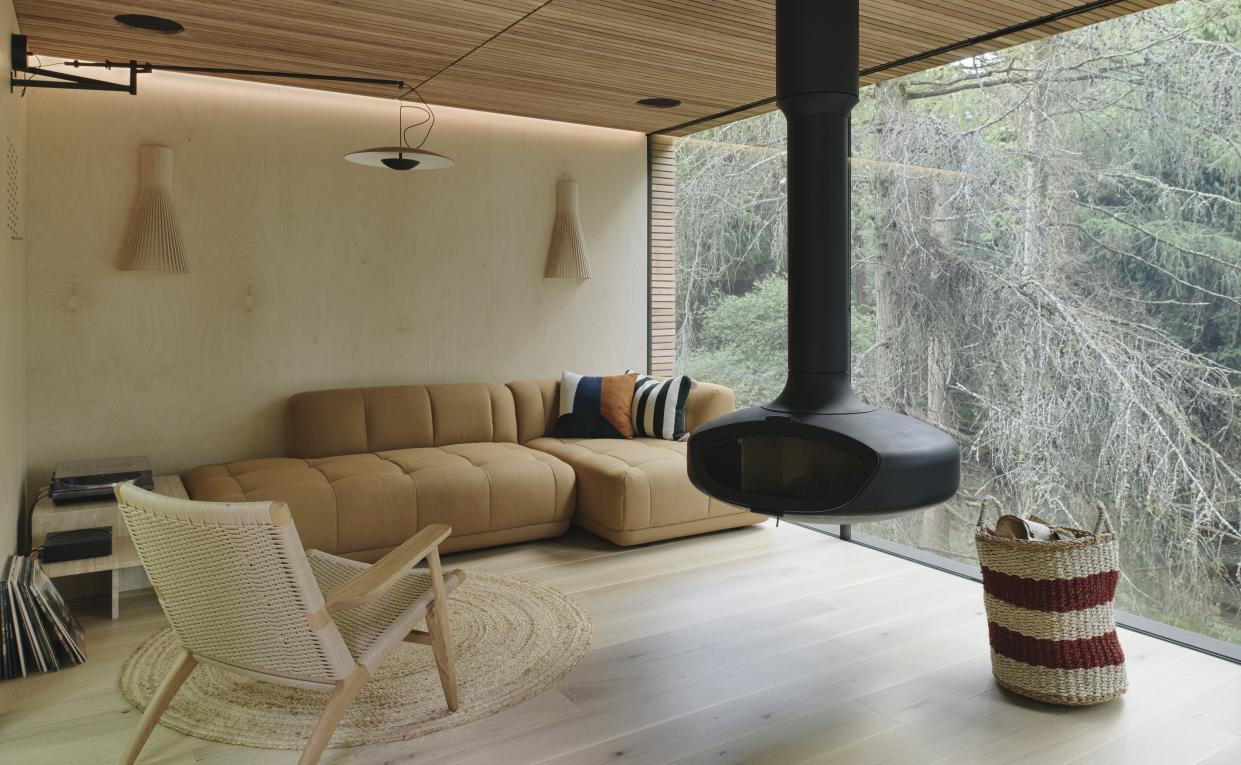  A cabin living room with suspended fireplace. 