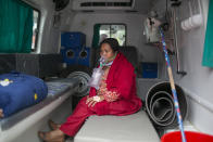 A COVID-19 patient receives oxygen in an ambulance outside an emergency ward of a hospital as she waits for a bed to be allotted at a government run hospital in Kathmandu, Nepal, Wednesday, May 12, 2021. Political turmoil has returned to Nepal, which has had eight different governments in a decade and is experiencing its worst COVID-19 surge with acute shortages of health facilities and oxygen for patients.(AP Photo/Niranjan Shrestha)