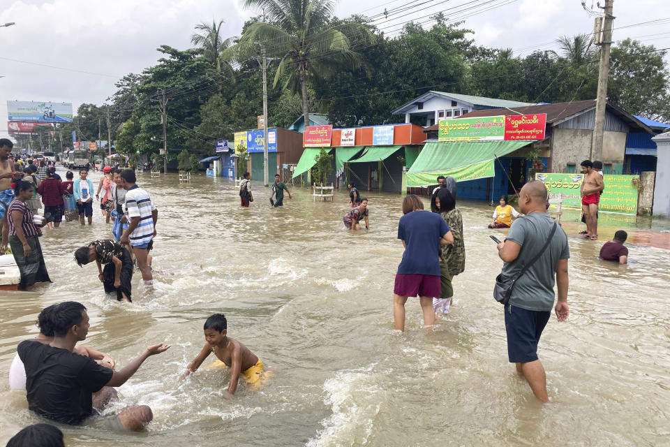 Local residents play on a flooded road in Bago, Maynmar, about 80 kilometers (50 miles) northeast of Yangon, Friday, Aug. 11, 2023. (AP Photo)