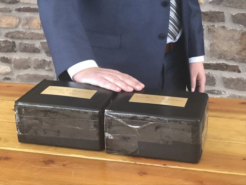 Montgomery County First Deputy Coroner Alexander Balacki touches the boxes holding the cremated remains of LeRoy and Lucille Bortner at a September 2019 interment ceremony at Washington Crossing Veterans Cemetery.