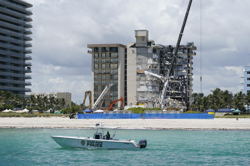 A Miami-Dade County Police boat patrols in front of the Champlain Towers South condo building, where search and rescue efforts continue more than a week after the building partially collapsed, Friday, July 2, 2021, in Surfside, Fla. (AP Photo/Mark Humphrey)