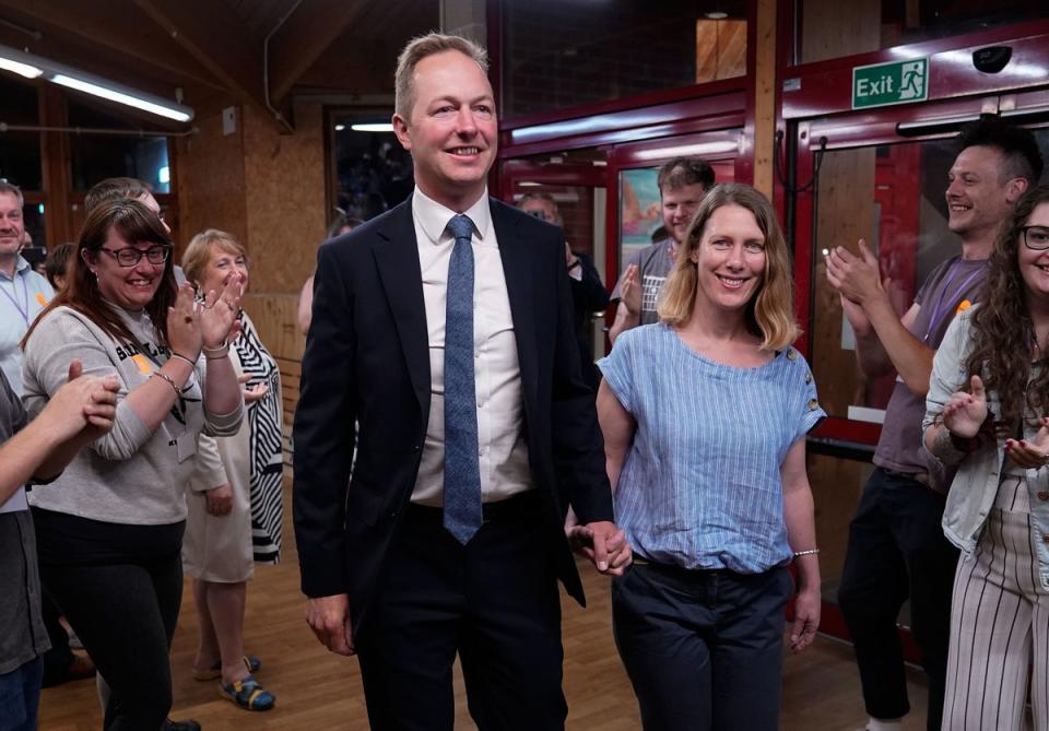 Richard Foord and his wife Kate arrive to cheers at the Tiverton by-election count (PA)