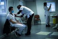 A nurse administrates a Pfizer/Biontech COVID-19 vaccine to a health care worker at the MontLegia CHC hospital in Liege, Belgium, Wednesday, Jan. 27, 2021. The 27-nation EU is coming under criticism for the slow rollout of its vaccination campaign. The bloc, a collection of many of the richest countries in the world, is not faring well in comparison to countries like Israel, the United Kingdom and the United States. (AP Photo/Francisco Seco)