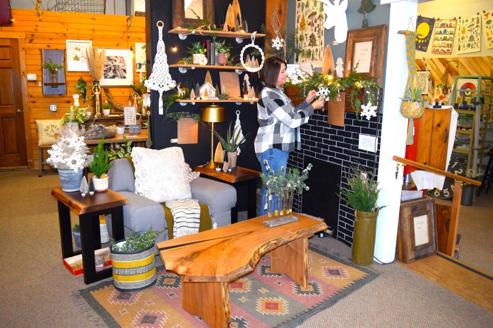 Kathy Hochstetler straightens a display at Studio 4 Designs in Berlin. The store features many unique homemade woodworking items created by her husband John.