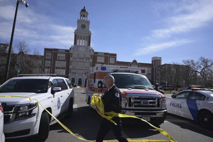 Emergency personnel remove police tape outside East High School after a school shooting on Wednesday in Denver. 