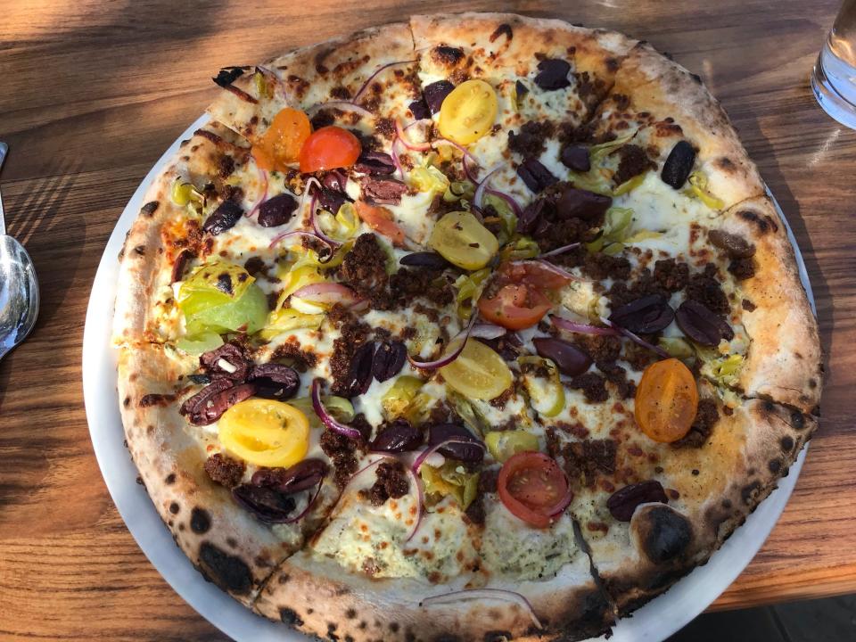 A pie from Pizzeria Gusto is served on the patio.