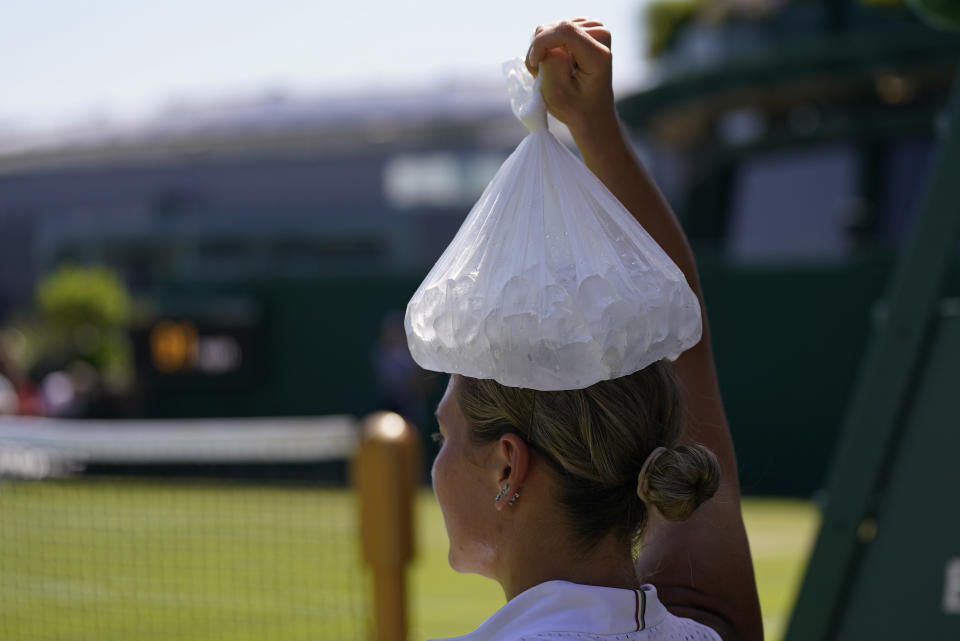 Ukraine's Marta Kostyuk places a bag of ice on her head as she tries to keep cool during a break as she plays Spain's Paula Badosa in a women's singles match on day five of the Wimbledon tennis championships in London, Friday, July 7, 2023. (AP Photo/Alberto Pezzali)